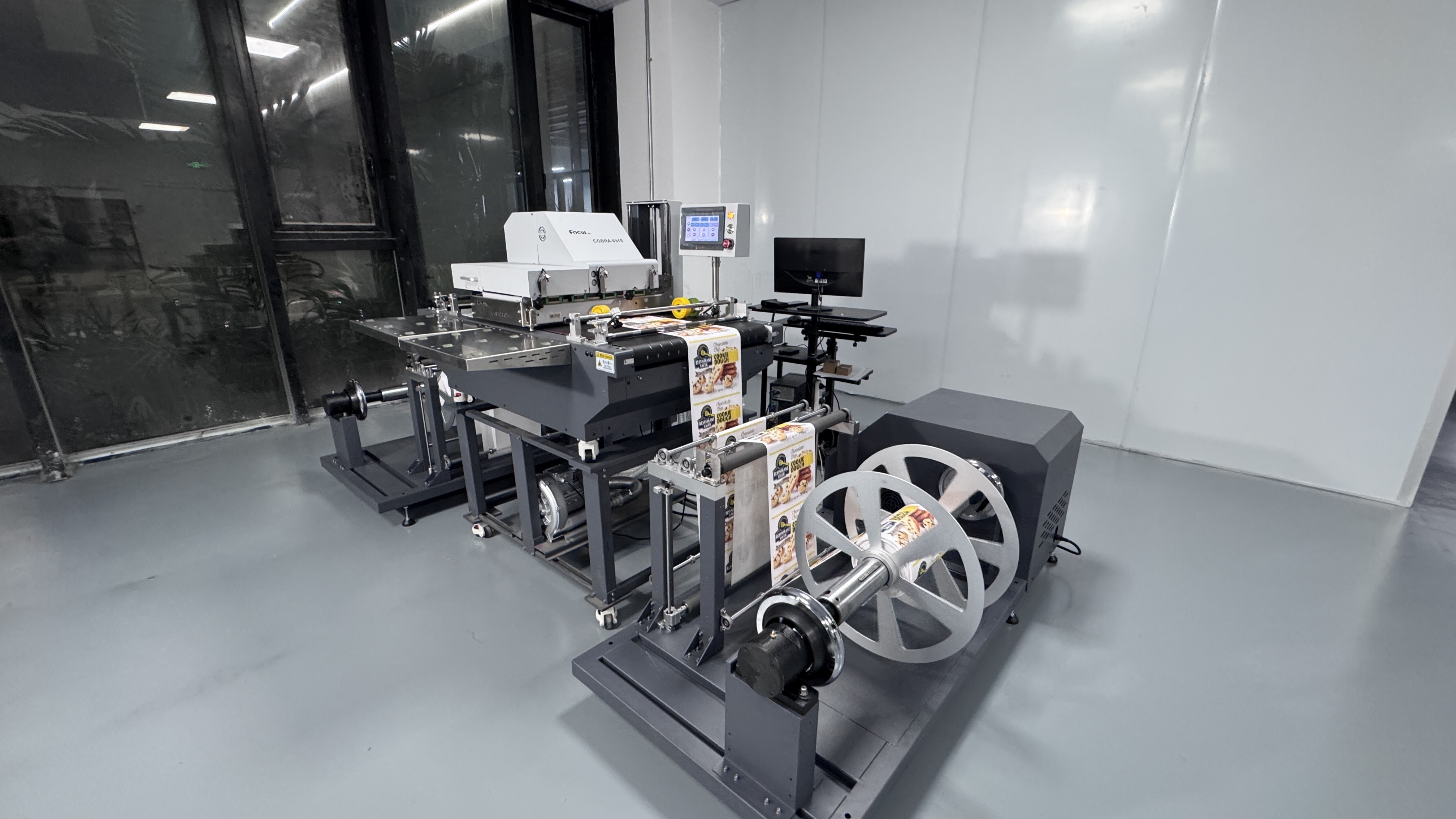 Custom roll-to-roll system for single pass label printing Custom unwinding and rewinding system for heavy label rolls integrated with a single pass printer